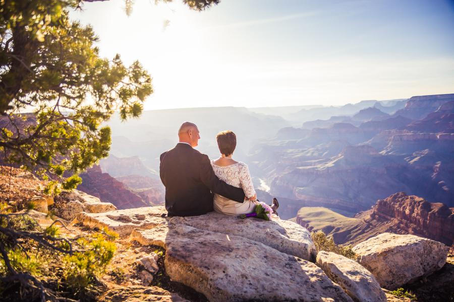 grand canyon wedding bride and groom sitting on the edge